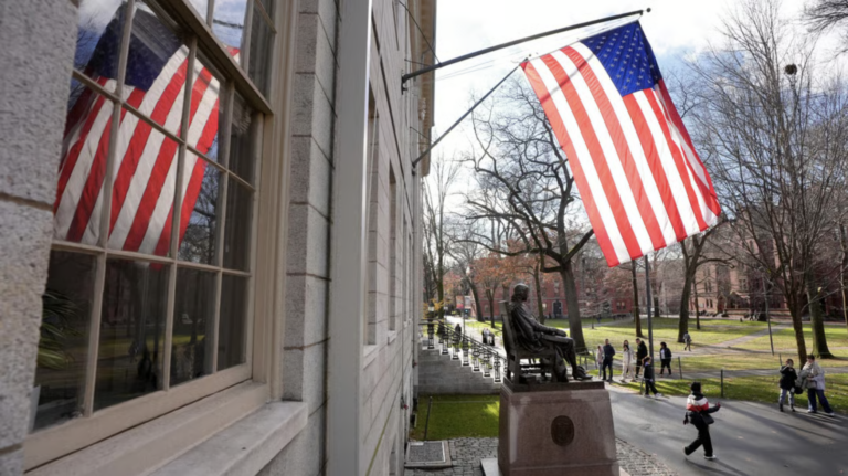 People walk past the John Harvard statue on the campus of Harvard University in Cambridge, Mass., Dec. 17, 2024. (AP Photo/Steven Senne, File)